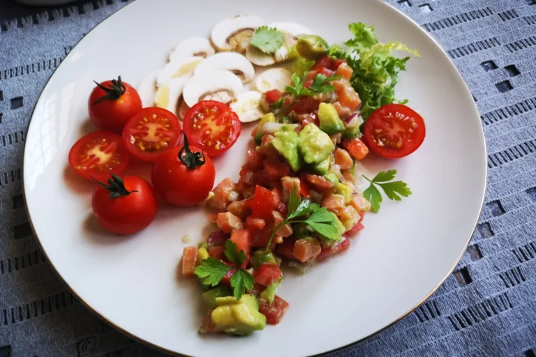 Tartar de salmón fresco crudo con aguacate, tomate y cebolla morada, plato sin cocción rico en omega-3