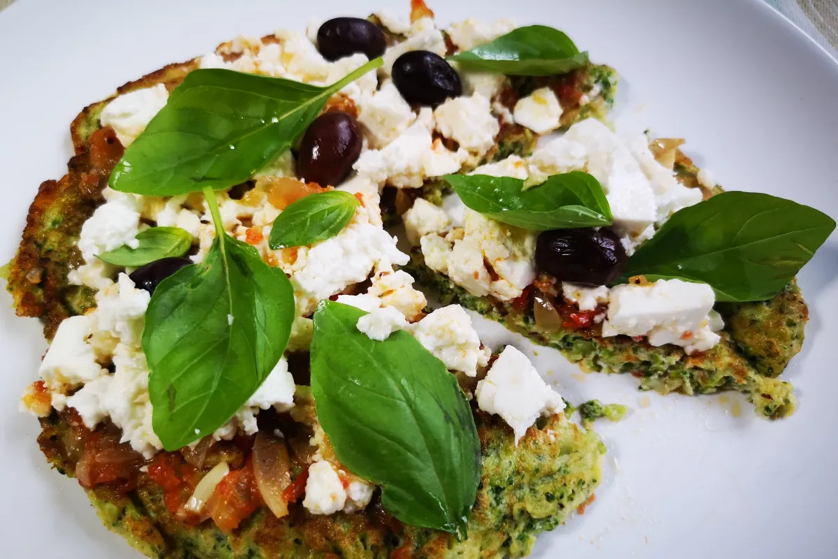 Pizza fresca con base de cuscús de brócoli sin harina, queso de cabra, albahaca y aceitunas negras, cena ligera