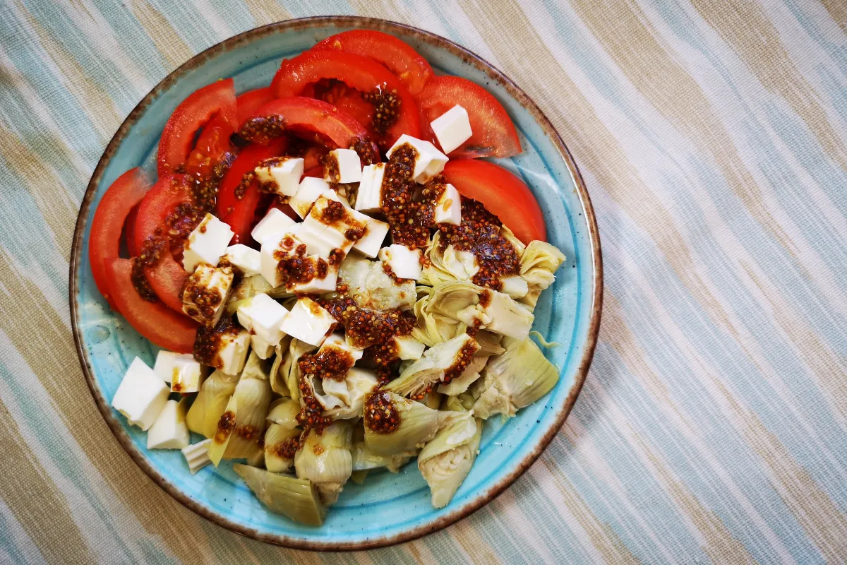 Ensalada mediterránea de alcachofas baby, tomate y queso fresco con vinagreta de mostaza