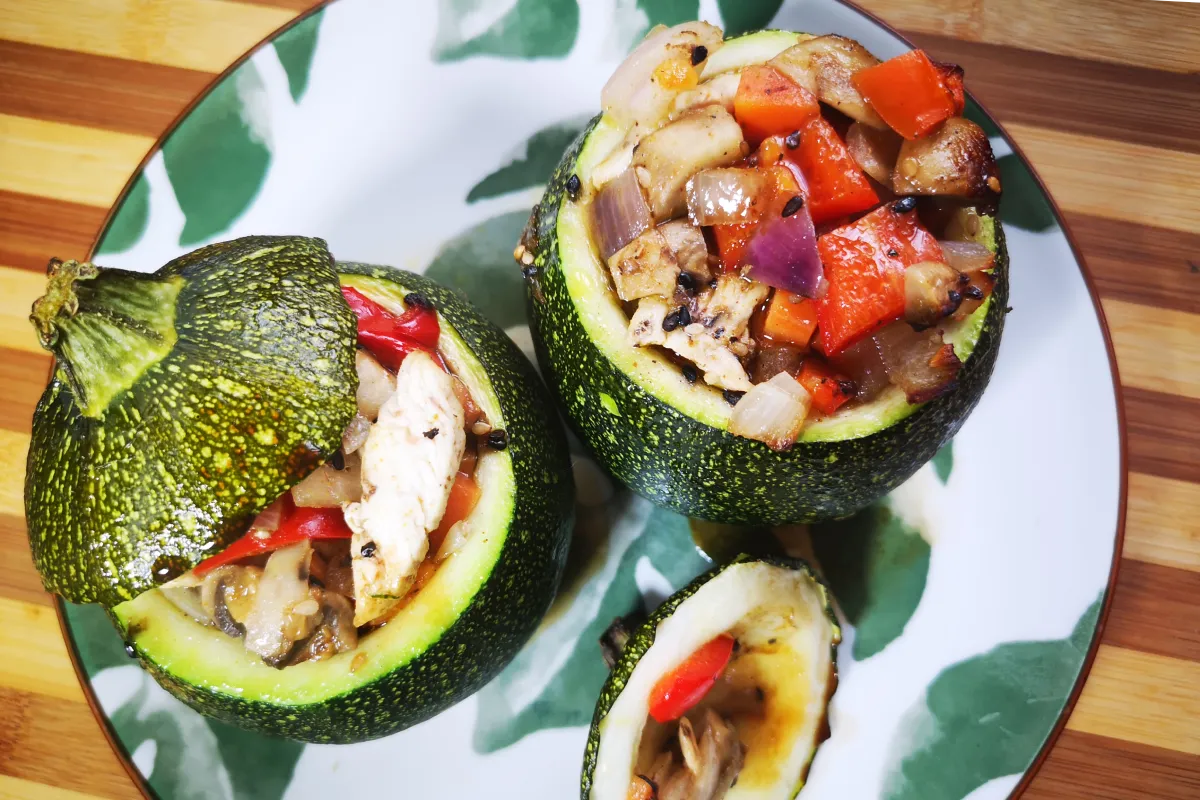 Calabacines redondos rellenos de pollo picado y verduras al curry, plato bajo en carbohidratos alto en proteína