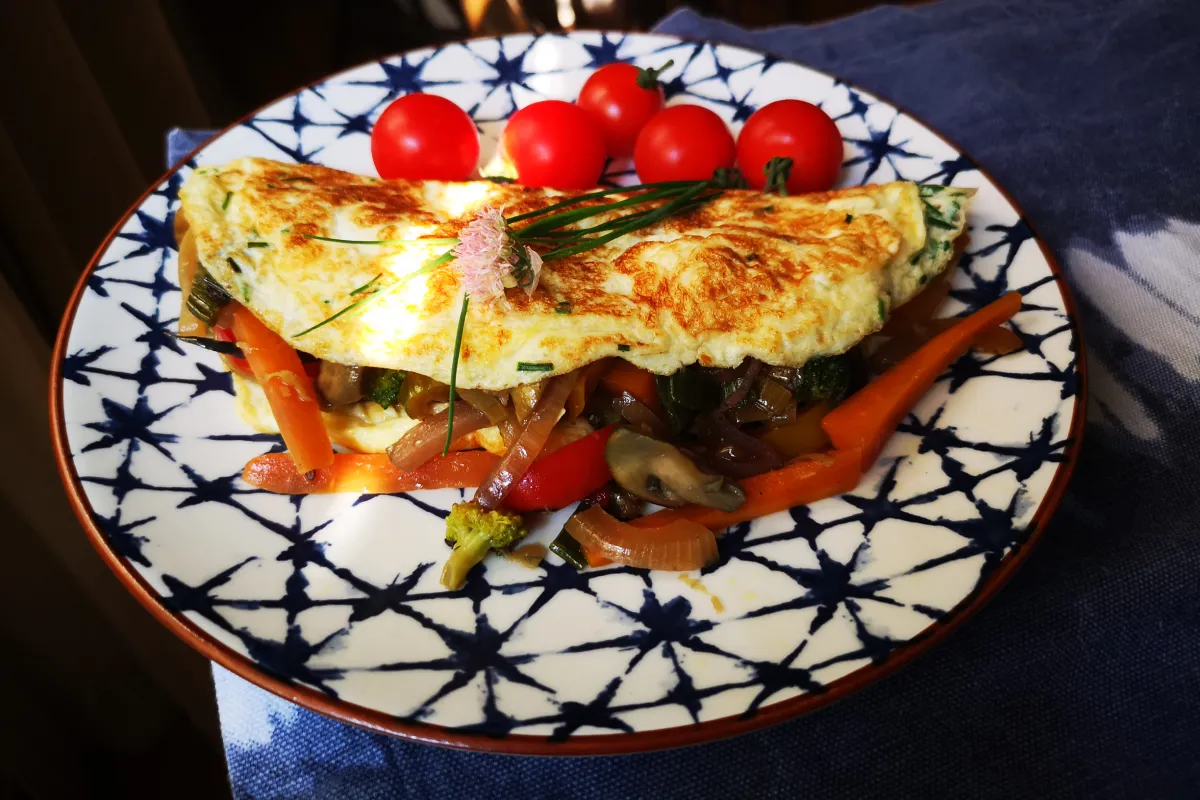 omelette relleno de verduras, una tortilla de huevo al estilo francés