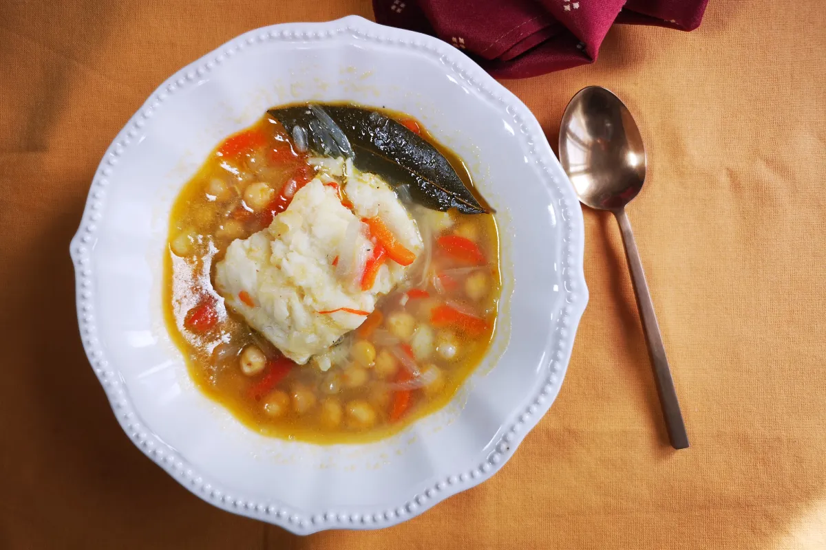 Cocido de garbanzos con bacalao y pimientos rojos, plato de cuchara tradicional reconfortante