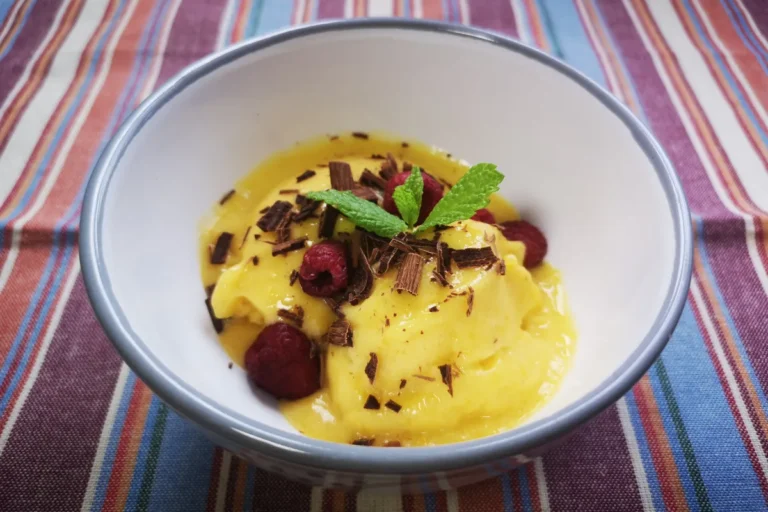 Bol de helado vegano de mango y plátano con frambuesas frescas, postre saludable 3 ingredientes