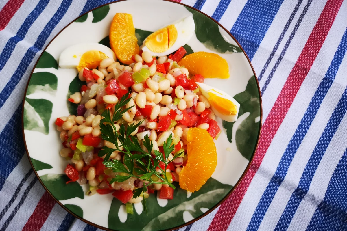Empedrat catalán de alubias blancas con bacalao desmigado, ensalada fresca del Empordà con naranja