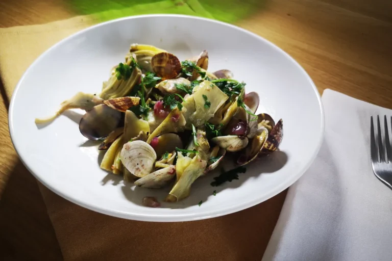 Alcachofas tiernas salteadas con almejas frescas abiertas al vapor, ajo y perejil, receta mediterránea ligera