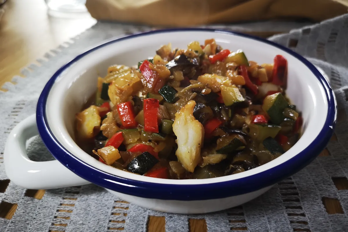 Pisto casero con cebolla, pimiento, calabacín, berenjena y bacalao jugoso, receta saludable mediterránea