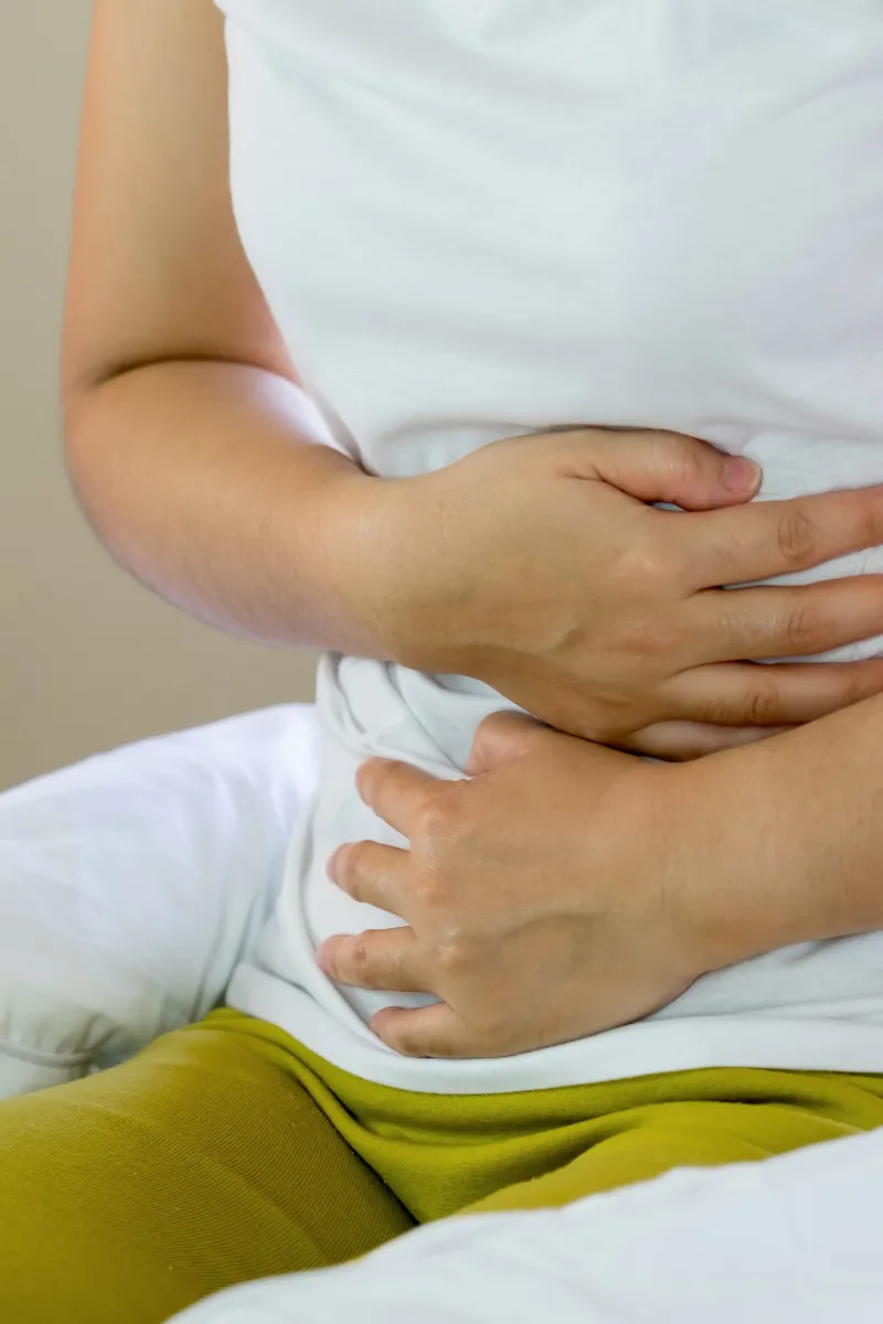 Mujer con malestar digestivo que se toca la barriga para calmar el dolor y busca un servicio de nutrición
